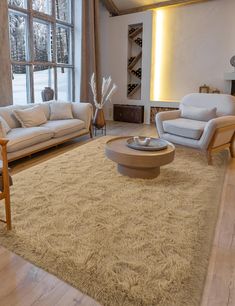 a living room with couches, chairs and a coffee table in front of a large window