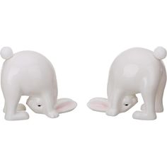 two white ceramic elephant figurines sitting next to each other on a white background