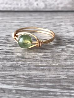 Worry ring made with a green, Jasper stoneTarnish resistant plated gold band Bead spins to offer a sense of calm Hand Wrapped Green Ring For Gift, Adjustable Green Rings For May Birthstone, Adjustable Green Crystal Promise Ring, Adjustable Green Round Birthstone Ring, Adjustable Spiritual Rings With May Birthstone, Green Jewelry With Round Band For Gift, Green Round Band Jewelry Gift, Green Stackable Round Jewelry, Gold Birthstone Ring With Natural Stones