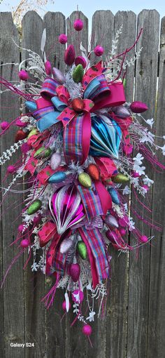 a colorful wreath on the side of a wooden fence