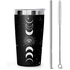 a black and white tumbler with the moon phases on it next to a straw