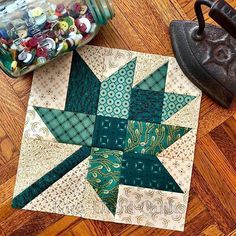 a green and white quilted star sitting on top of a wooden floor next to a canister