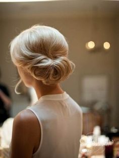 the back of a woman's head with her hair in a low bun