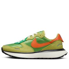 a green and orange sneaker with white soles on the bottom, in front of a