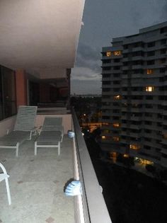 an empty balcony at night with lounge chairs