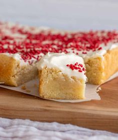 a piece of cake with white frosting and red sprinkles on it