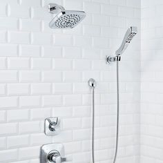 a shower head with thermostaer and hand held shower faucet in white tiled wall