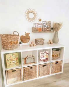 a white shelf filled with baskets and books