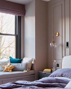 a bed sitting next to a window in a bedroom