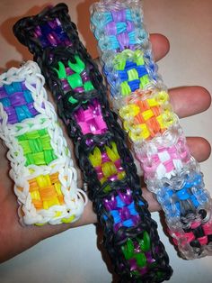 three bracelets made out of plastic beads in different colors and sizes are held by someone's hand