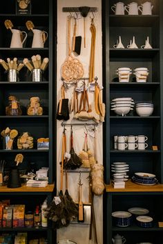 the shelves are filled with many different items and things to eat in them, including utensils