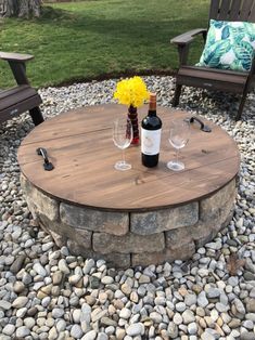 a table with two wine glasses and bottles on top of it next to some chairs