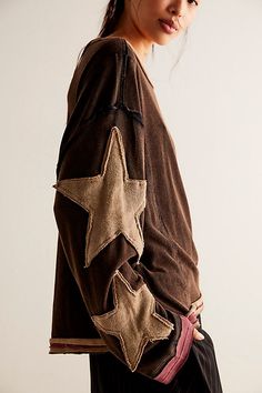 a young woman wearing a brown jacket with stars on it