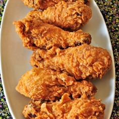 three pieces of fried chicken on a white plate