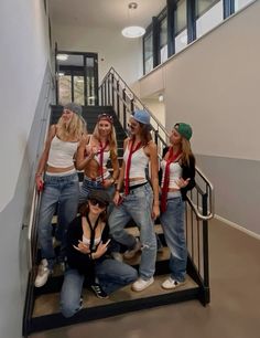 a group of young women standing on top of a stair case next to each other