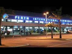 an international terminal lit up at night with palm trees