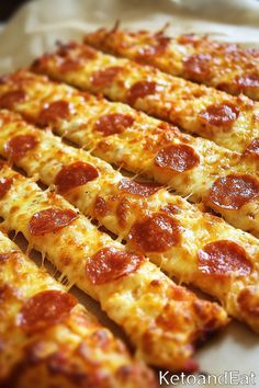 pepperoni pizza slices are arranged in rows on a baking sheet, ready to be eaten