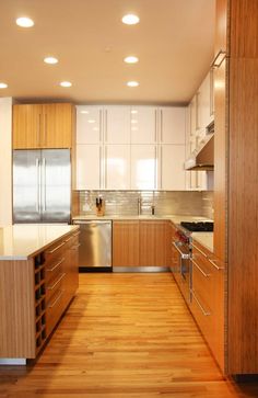 a kitchen with wooden floors and white cabinets