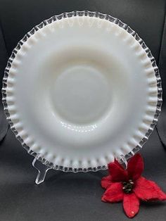 a white plate sitting on top of a table next to a red poinsetti