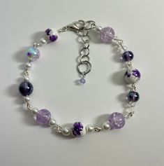 a floral grape colored bracelet that feels like a European spring day. If your a fan of purple this is a great touch to your jewelry. Made with  quality beads and strong links. Purple Flower-shaped Beaded Bracelets, Purple Flower Shaped Beaded Bracelets, Hypoallergenic Purple Flower Jewelry, Purple Beaded Flower Bracelets, Purple Flower Jewelry For Spring, Elegant Hypoallergenic Purple Beaded Bracelets, Adjustable Purple Flower Beaded Bracelets, Elegant Purple Beaded Charm Bracelet, Elegant Purple Adjustable Bracelets