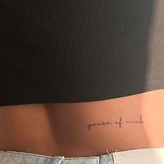 a woman's stomach with the words peace of mind written on her lower back