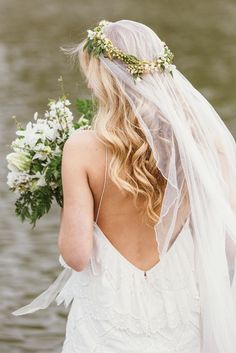 the back of a bride's wedding dress with flowers in her hair and veil