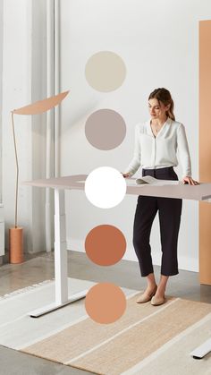 a woman standing in front of a table with circles on the wall behind her,