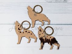 three wooden key chains with two wolfs on them