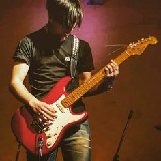 a man playing an electric guitar on stage