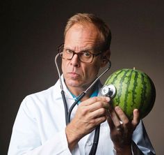 a doctor holding a watermelon with a stethoscope in his hand