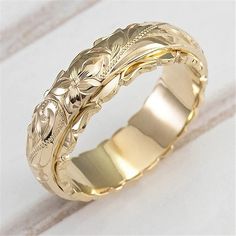 a gold wedding band with an intricate design