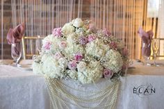 a bouquet of white and pink flowers sitting on top of a table