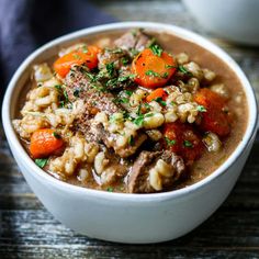 a white bowl filled with stew and carrots