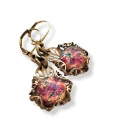 Hand crafted Art Deco Era, Lalique style inspiration, glass fire opal earrings. The stones have a pink base, with highlights of gold, aqua, green and red. When they catch the light, they seem to glow with fire from within.  I hand sculpted the filigree setting for them.  * Drop approx. .75" L x 5/8" W (19mm L x 16mm W)   *   Full length including ear wires approx. 1.5" L (33mm L)  * Finish: Antique gold-tone patina on solid brass.  * Stone: Glass fire opals are premium quality unworn vintage stock, Artisan made in Czechoslovakia.  * Solid brass hand forged ear wires * All metal components are high quality solid brass, lead and nickel free. * Packaged in a beautifully presented gift box with organza ribbons ready for gifting Limited Availability: Each piece is handcrafted and unique, availa Metal Earrings With Artistic Design For Gifts, Fusion Style Artistic Earrings For Gift, Artistic Handmade Jewelry For Celebration, Artistic Design Jewelry For Party, Artistic Jewelry For Party, Artistic Jewelry For Party With Artistic Design, Nickel-free Art Nouveau Earrings As Gift, Art Nouveau Dangle Earrings For Gifts, Iridescent Bohemian Earrings As Gift