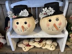 two snowmen sitting on top of a white shelf