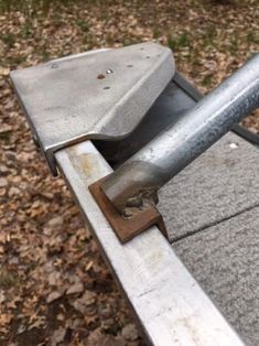 an old metal bench sitting on top of leaves