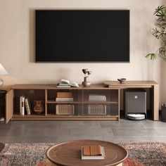 a living room with a large flat screen tv mounted on the wall above it's entertainment center