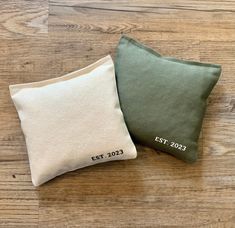 two green and white pillows sitting on top of a wooden floor next to each other