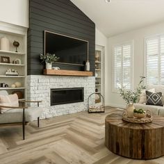 a living room with white brick fireplace and wood flooring