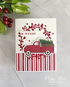 a christmas card with a red truck carrying a tree on the back and merry lettering