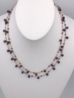 - Amethyst and Pearl double stranded necklace - Tear Drop briolettes (7-8mmL) and faceted Amethyst beads (2-3mmL) - 14-karat yellow gold-filled hardware - Pearl dimensions approx. 3mm - Lobster clasp - Approx. 18-20"L - Made in the USA Faceted Amethyst Briolette Necklace, Purple Faceted Briolette Necklace, Purple Briolette Faceted Necklace, Elegant Purple Faceted Beads Gemstones, Purple Briolette Crystal Necklace, Purple Double Strand Jewelry With Natural Stones, Double Strand Purple Jewelry With Natural Stones, Purple Double Strand Natural Stones Jewelry, Amethyst Briolette Necklace For Jewelry Making