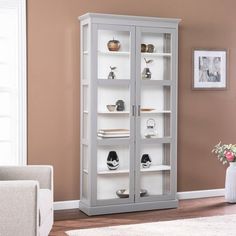 a white bookcase with glass doors in a living room