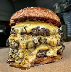 a cheeseburger sitting on top of a piece of bread covered in melted cheese