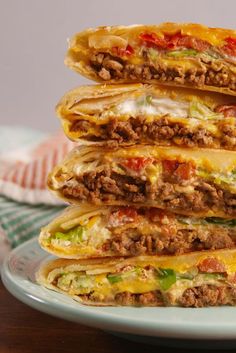 a stack of quesadillas stacked on top of each other with meat and cheese