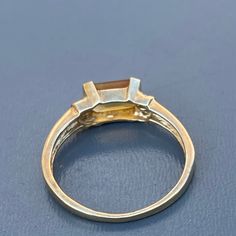 Vintage ~ 10kt solid yellow gold ring with openback ,bezel set faceted Citrine stone ring and three tiny diamonds on each sides ~ Marked 10kt with initials AJ Materials :- 14kt solid gold ( not plated ) genuine Citrine stone (electronically tested ) ..measures 1 1 /8 inches x 3/4 inches wide x approx 1/2 inches in depth Measurements :- ring can fit size 6 1/2 - 7 . Weighs 1 grams on my weighing scale . Condition :- Overall ring is in good vintage condition ~ No cracks /chips to stone . Please No Gold Birthstone Ring With Bezel Setting And Emerald Cut, 14k Gold Three-stone Emerald Cut Diamond Ring, 14k Gold Three Stone Emerald Cut Diamond Ring, 14k Gold Solitaire Topaz Ring With Emerald Cut, 14k Gold Emerald Cut Solitaire Topaz Ring, Emerald Cut Solitaire Topaz Ring In 14k Gold, Gold Topaz Baguette Cut Ring In 14k Gold, Gold Topaz Ring With Baguette Cut, Gold Baguette Cut Topaz Ring In 14k Gold