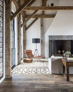 a living room with wooden beams and white furniture in the center, along with a fireplace