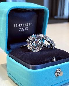 a diamond ring sits in a blue box