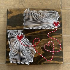 string art on wood with red and white beads