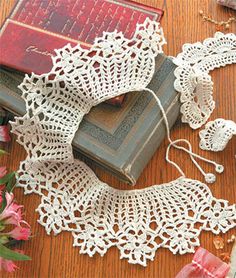 lace and flowers on a wooden table next to an open book