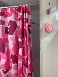 the shower curtain is pink and has hearts on it